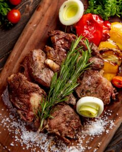 carne-frita-servida-vegetales-parrilla-cebolla-ramita-romero_141793-741